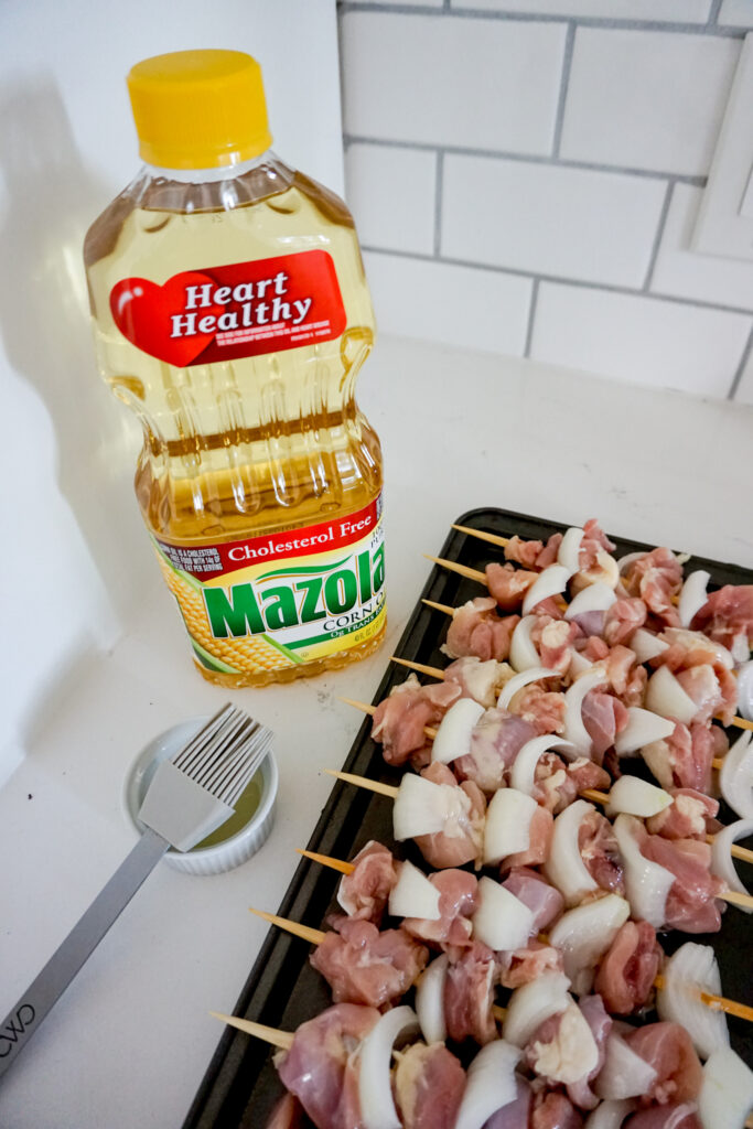 Mazola® Corn Oil with raw chicken yakitori skewers.