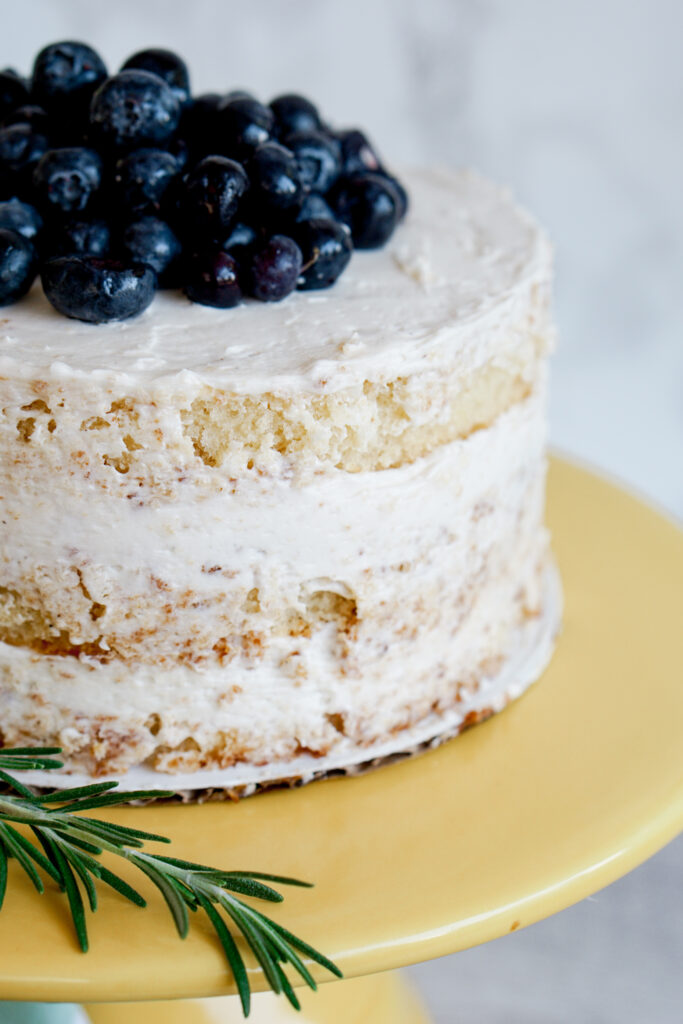 6" three layer lemon naked cake with blueberries on top and rosemary on the side