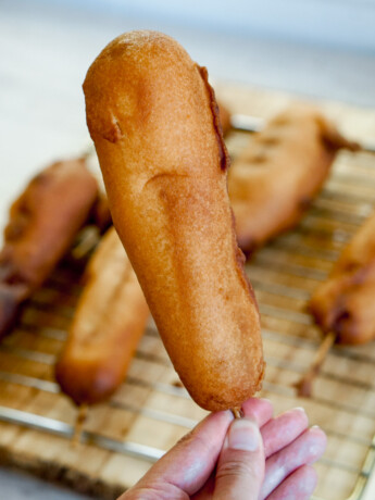 closeup of an andagi dog on a stick held by a hand