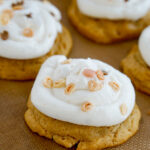 angled closeup of cakey pumpkin cookies with cream cheese frosting and Halloween sprinkles