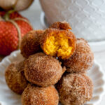 pumpkin mochi donuts closeup with a bite taken out the top donut