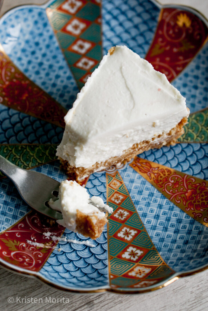 no-bake yogurt cheesecake slice on a plate with tip scooped off on fork