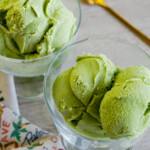 two clear ice cream bowls with scoops of green matcha ice cream