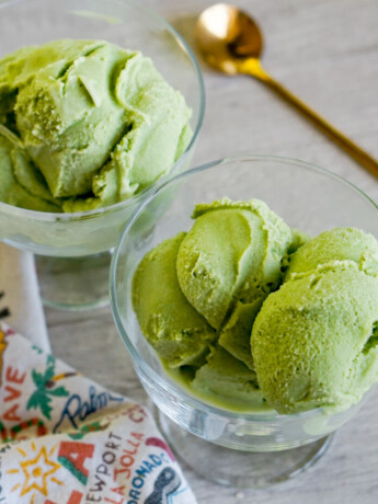 two clear ice cream bowls with scoops of green matcha ice cream