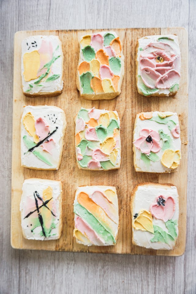 Rectangular cut out shortbread cookies with American buttercream frosting. The buttercream is painted on in an abstract effect using a spatula.
