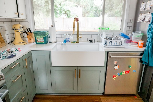 white farmhouse sink with gold faucet