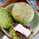 a round matcha scone split in half with a spread of red bean paste (anko) and a pat of butter on top