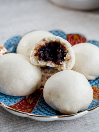 steamed red bean bun stacked in pyramid with top cut in half to see red beans inside
